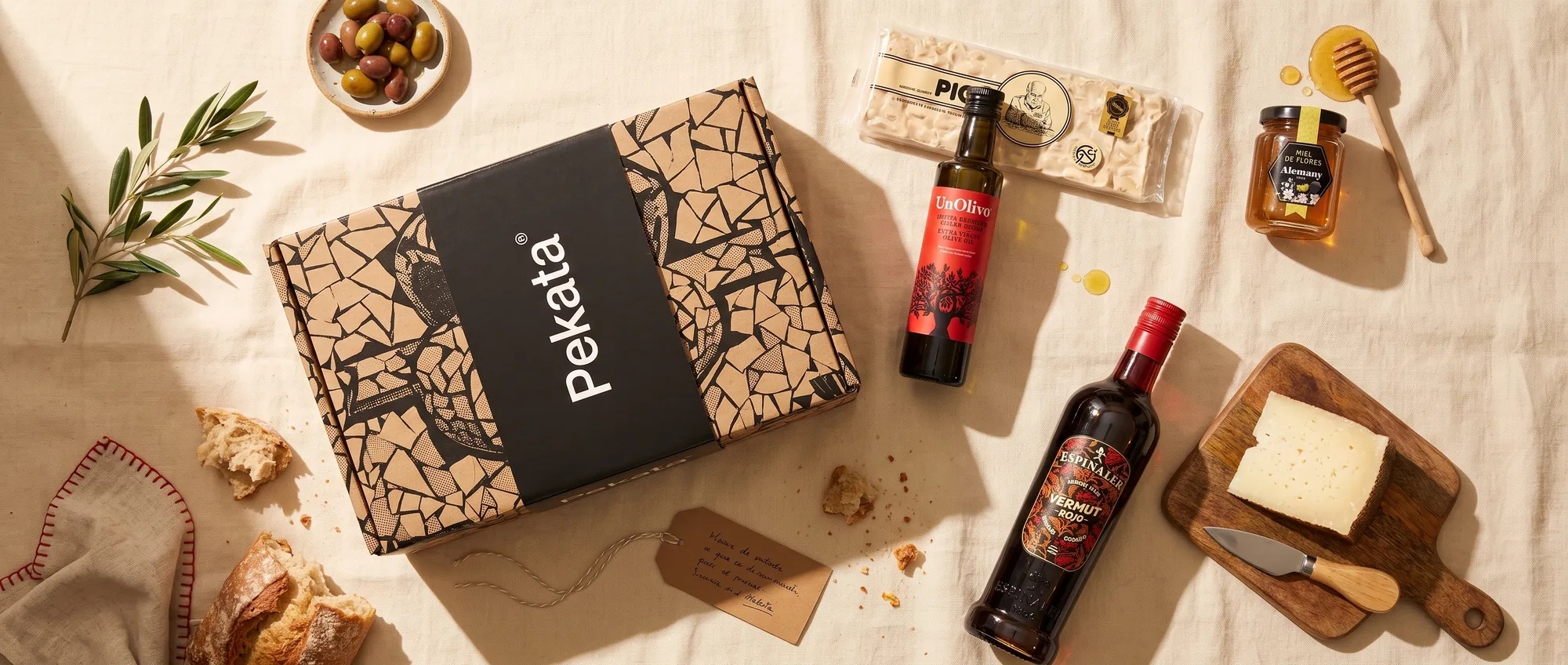 Coffret de Noël Pekata avec touron artisanal, miel, huile d'olive et vermouth sur une table
